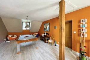 Salle de billard à l’étage de la maison à vendre à Moisville dans l’Eure avec décoration moderne et poutre apparente