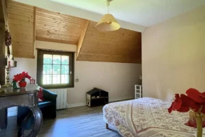Chambre familiale à l’étage avec fenêtre sur jardin dans une maison normande à Bonneville-la-Louvet.