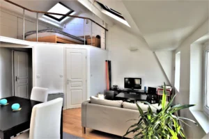 Loft à Paris 9 Notre-Dame-de-Lorette avec chambre en mezzanine, salon cosy et lumière traversante sous verrière.