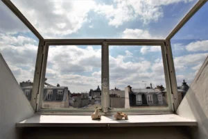 Vue dégagée sur les toits parisiens depuis l’appartement situé rue de Turenne, à proximité de la Place des Vosges dans le 3ᵉ arrondissement.