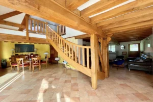 Grand salon de la maison à vendre à Moisville dans l’Eure avec escalier en bois massif et espace salle à manger