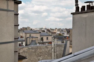 Vue panoramique sur les toits parisiens avec le Sacré-Cœur en arrière-plan, depuis l’appartement rue de Turenne Paris 3ᵉ.