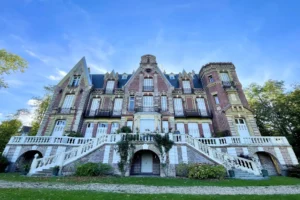 Façade principale du château de Villers-sur-Mer, bâtiment de caractère en briques et pierre typiquement normand, entouré de verdure dans le Calvados.