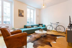 Salon lumineux avec grandes fenêtres, parquet en bois, décoration moderne et terrasse attenante – appartement à vendre Paris 9 Saint-Georges
