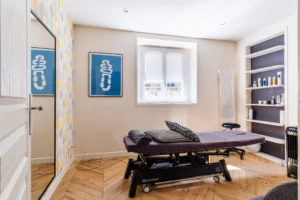 Pièce polyvalente lumineuse avec parquet en chevron, étagères murales et fenêtre sur cour, Paris 10 – Gare de l’Est.