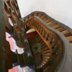 Escalier ancien en bois massif typique des immeubles parisiens, photographié depuis les étages supérieurs d’un bâtiment à Paris 2 Montorgueil.