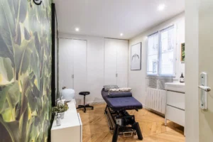 Pièce lumineuse avec papier peint végétal, rangements intégrés et parquet en chevron, appartement Paris 10 – Gare de l’Est.