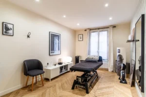 Pièce supplémentaire avec parquet ancien et grandes fenêtres, murs clairs et mobilier épuré, Paris 10 – Gare de l’Est.