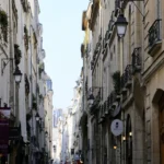 Vue animée de la rue Montorgueil à Paris 2, bordée d’immeubles anciens et de commerces typiques, au cœur d’un quartier vivant et recherché.