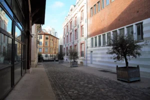 Vue sur la Villa Marcel Lods à Paris 19, une voie pavée bordée d’immeubles d’ateliers typiques du quartier Belleville – Buttes Chaumont.