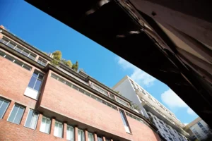 Façade en briques rouges typique de la Villa Marcel Lods à Paris 19, avec architecture moderniste et toits végétalisés dans le quartier de Belleville.