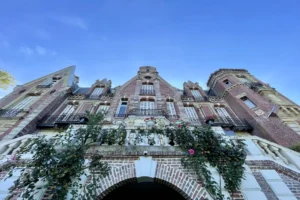 Détail architectural de la façade du château de Villers-sur-Mer, soulignant les briques rouges, les pierres sculptées et les balcons en fer forgé typiques du Calvados.