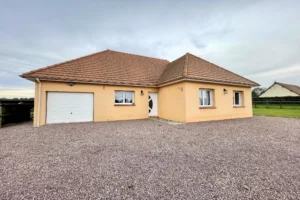 Façade principale d’une maison moderne à Le Torquesne 14130, avec garage intégré, allée en gravier et toiture en tuiles dans un environnement calme du Calvados.