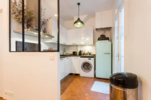 Cuisine équipée moderne avec verrière, carrelage en terre cuite et électroménager – appartement Paris 9 Saint-Georges