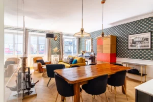 Salle à manger conviviale avec table en bois massif ouverte sur un séjour lumineux, quartier Gare de l’Est à Paris 10.