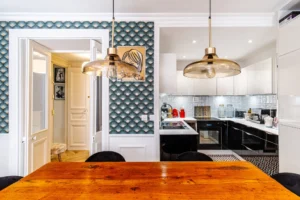 Cuisine ouverte moderne avec façades laquées blanches et crédence en carreaux relief, attenante à la salle à manger, Paris 10 – Gare de l’Est.