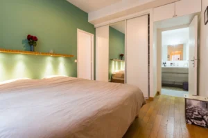 Chambre avec grands rangements intégrés, miroir et accès salle de bains – appartement Paris 9 Saint-Georges