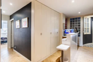 Couloir avec grands placards intégrés et coin bureau moderne, accès vers l’espace nuit, Paris 10 – Gare de l’Est.