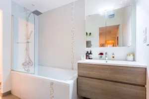 Salle de bains moderne avec baignoire, meuble vasque en bois et miroir – appartement Paris 9 Saint-Georges