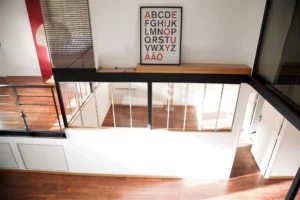 Vue en hauteur d’un loft à Paris 19, Villa Marcel Lods, montrant la verrière intérieure, le parquet et les volumes ouverts baignés de lumière naturelle.