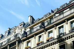 Façade haussmannienne de la rue du Faubourg Saint-Denis avec balcons filants, pierre de taille et toitures mansardées sous un ciel bleu dans le 10ᵉ arrondissement.