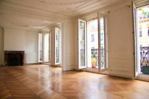 Grand séjour haussmannien lumineux avec parquet point de Hongrie, moulures, cheminée en marbre et balcon filant donnant sur la rue Beaurepaire à Paris 10 – Canal Saint-Martin.