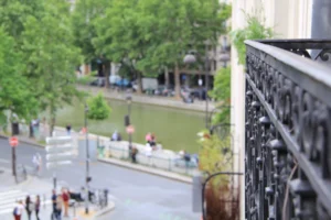 Vue depuis le balcon sur le Canal Saint-Martin, la rue Beaurepaire et les quais animés du 10ᵉ arrondissement de Paris.