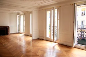 Double séjour haussmannien lumineux avec parquet point de Hongrie, moulures et accès au balcon filant donnant sur la rue Beaurepaire à Paris 10.