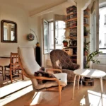 Salon lumineux avec fauteuils, table basse, parquet en chêne et fenêtres ouvertes dans un appartement rue Poissonnière Paris 2.