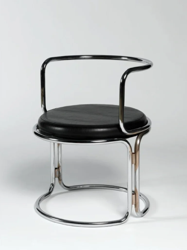 Fauteuil dessiné par Gae Aulenti en 1969 pour Prisunic, structure tubulaire en acier chromé et coussin circulaire en skaï noir, emblème d’un design industriel accessible et épuré.