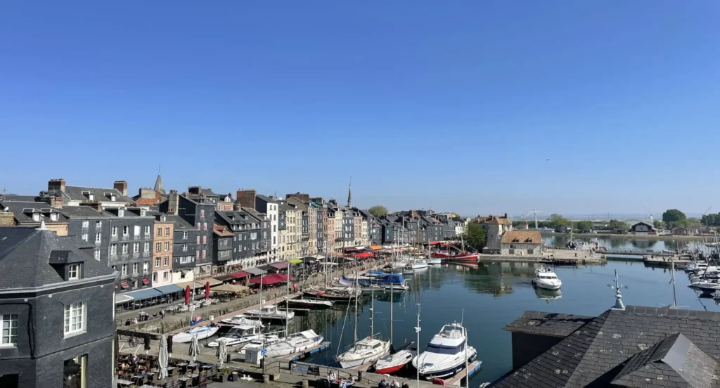 Vue imprenable sur le Vieux Bassin de Honfleur et ses façades colorées depuis un appartement à vendre dans le Calvados, Quality Street Immobilier.