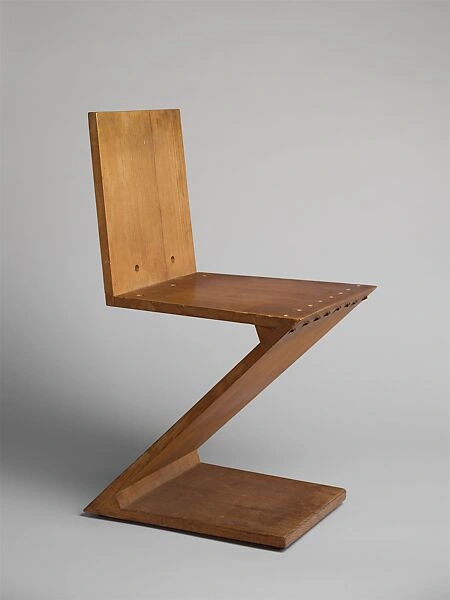 Chaise Zig-Zag conçue en 1934 par Gerrit Thomas Rietveld, réalisée en bois, aux lignes géométriques en forme de Z, emblématique du mouvement De Stijl.