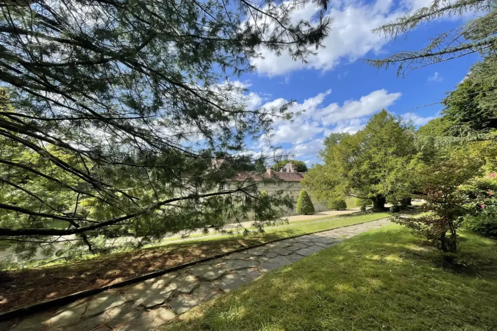Château et jardins de Boutemont à Ouilly-le-Vicomte — allée paysagère, arbres et perspective sur le domaine dans un cadre naturel en Normandie.