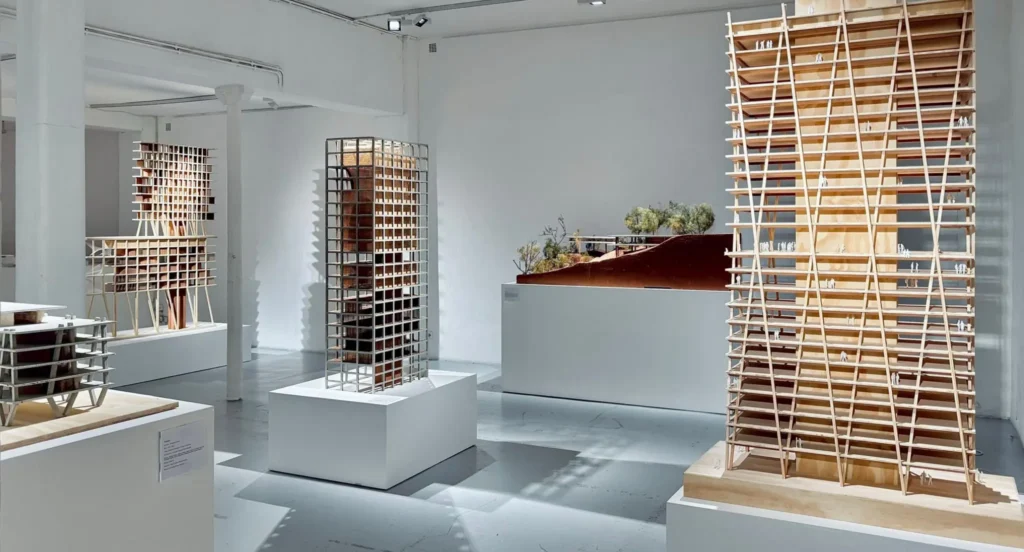 Vue d’ensemble de l’exposition Corps mort / Corps vivant à la Galerie d’Architecture à Paris, présentant plusieurs maquettes architecturales de l’agence Triptyque.