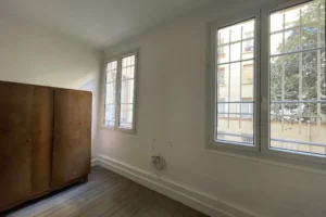 Chambre sur cour d’un appartement à vendre à Paris 11, boulevard du Temple, pièce lumineuse avec parquet, fenêtre et ambiance calme.