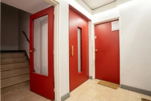 Palier d’étage avec porte d’entrée de l’appartement, parties communes propres d’un immeuble avec ascenseur à Paris 12 secteur Dugommier Daumesnil.