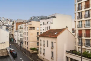 Vue dégagée depuis le séjour d’un appartement à vendre à Paris 12 Picpus, donnant sur la rue de la Voûte, façades d’immeubles parisiens, environnement urbain calme et résidentiel.