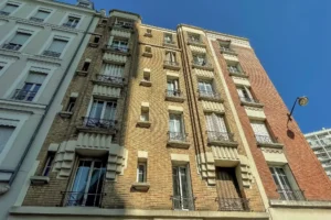 Façade sur rue d’un immeuble en brique datant de 1935, situé rue Rondelet à Paris 12 Reuilly-Diderot, avec balcons en fer forgé et modénatures d’époque.