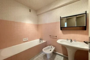 Salle de bains d’un appartement 4 pièces à vendre à Paris 12 Bel Air, avec baignoire, lavabo, bidet, carrelage d’origine et fort potentiel de rénovation.