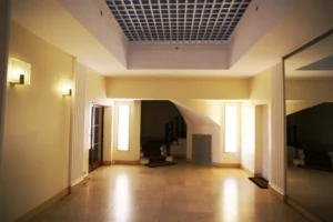 Hall d’entrée d’un immeuble ancien à Paris 16 Molitor, espace soigné avec éclairages muraux, colonnes, sol en pierre et accès à la cage d’escalier.