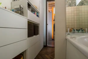 Rangements sur mesure dans la salle de bains, meubles intégrés et circulation optimisée dans un appartement à Paris 10.