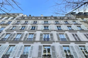 Façade d’un immeuble parisien en pierre avec volets et balcons, bâtiment dans lequel se situe l’appartement à vendre à Paris 11, boulevard du Temple.