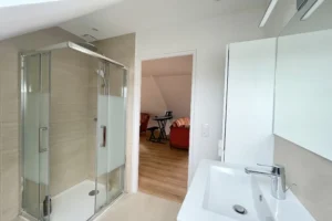 Salle d’eau à l’étage avec douche vitrée, meuble vasque contemporain et carrelage clair, maison à vendre à Saint-Benoît-d’Hébertot.