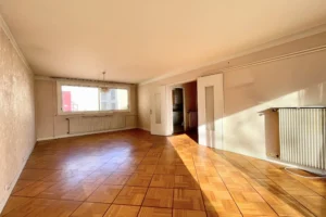 Grande pièce de vie d’un appartement 4 pièces à vendre à Paris 12 Bel Air, beaux volumes, parquet d’origine, lumière naturelle traversante et fort potentiel de rénovation.