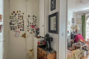 Entrée d’un appartement à Paris 17 Pont Cardinet avec rangements, porte d’entrée ancienne et aperçu du salon aux éléments de charme.