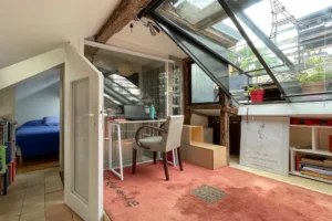 Espace bureau sous verrière avec lumière zénithale, coin nuit en mezzanine et rangements intégrés dans un appartement de caractère à Paris 10.