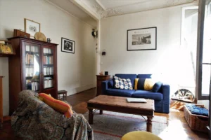Salon d’un appartement à Paris 5, quartier des Gobelins, avec parquet ancien, moulures au plafond, espace de vie chaleureux.