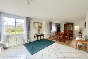 Cuisine vue depuis l’espace repas avec îlot et rangements, maison familiale à vendre à Saint-Benoît-d’Hébertot.