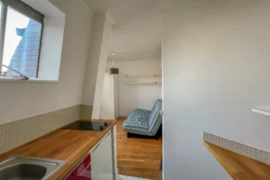 Vue depuis l’espace cuisine d’un appartement à Paris 15 vers la pièce principale, mettant en valeur le parquet, la circulation fluide et l’agencement optimisé.