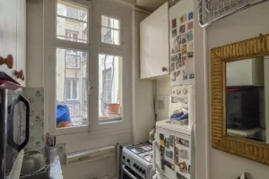 Cuisine sur cour d’un appartement à Paris 17 Pont Cardinet, fonctionnelle et lumineuse, avec fenêtre donnant sur une cour intérieure calme.